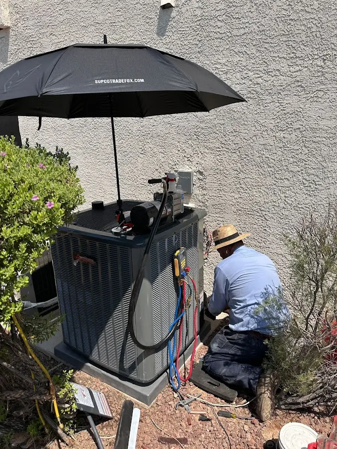 HVAC technician performing outdoor AC maintenance in Delano