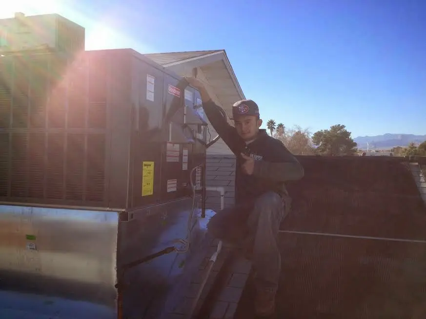 HVAC technician performing Air Duct Repair on a rooftop unit in Delano
